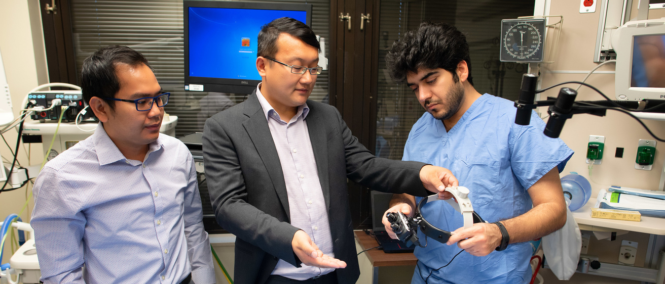 Researchers discussing Smart Goggles developed by Yang Liu's group