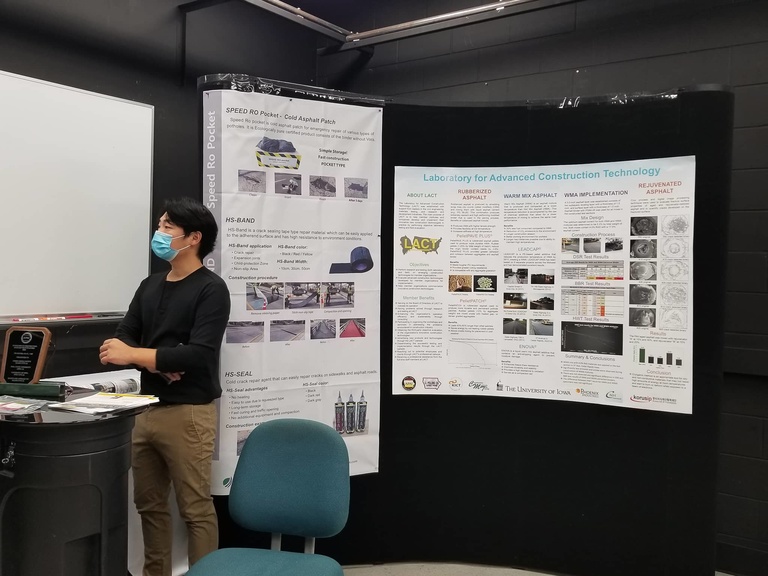 A researcher standing in front of posters