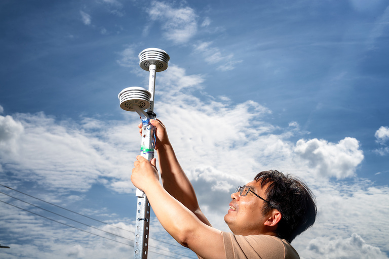 Jun Wang adjusting an atmospheric sensor