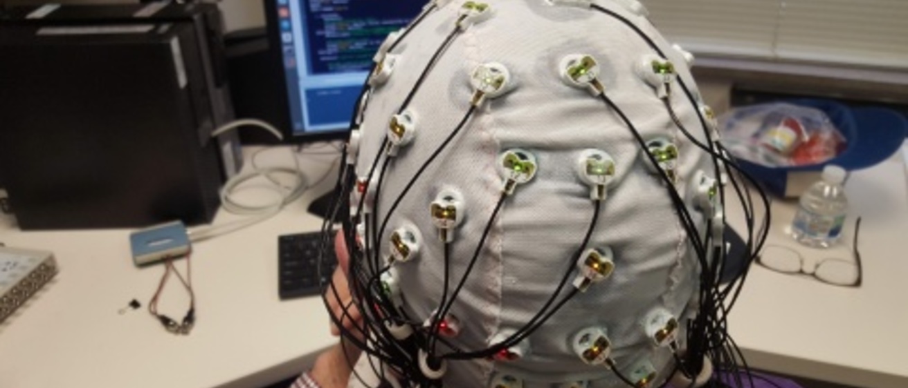 Person wearing a cap with attached sensors