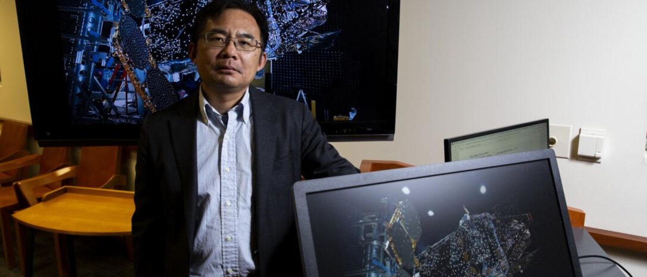 Jun Wang stands in front of a computer sceen