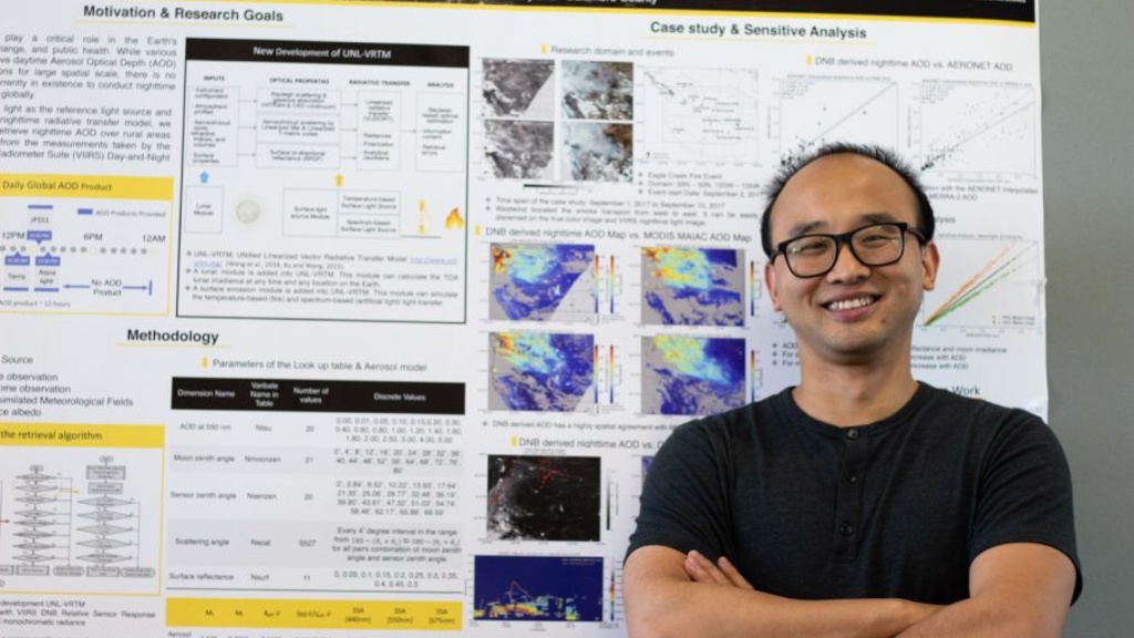 Meng Zhou poses in front of his research