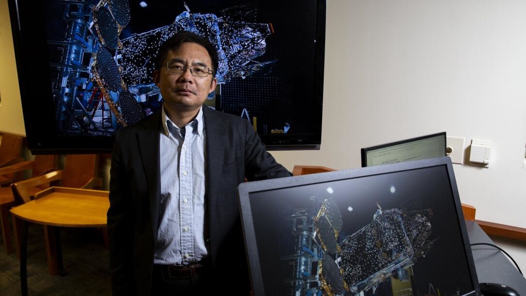 Jun Wang stands in front of a computer sceen