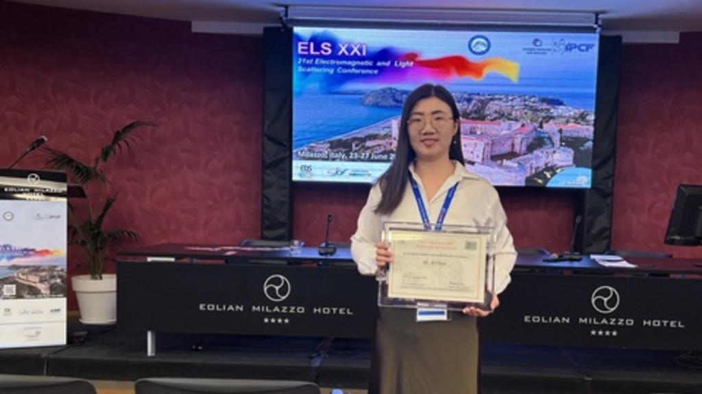 Xi Chen poses with an award
